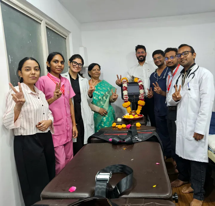 Group beside the newly installed spine decompression machine at the clinic.